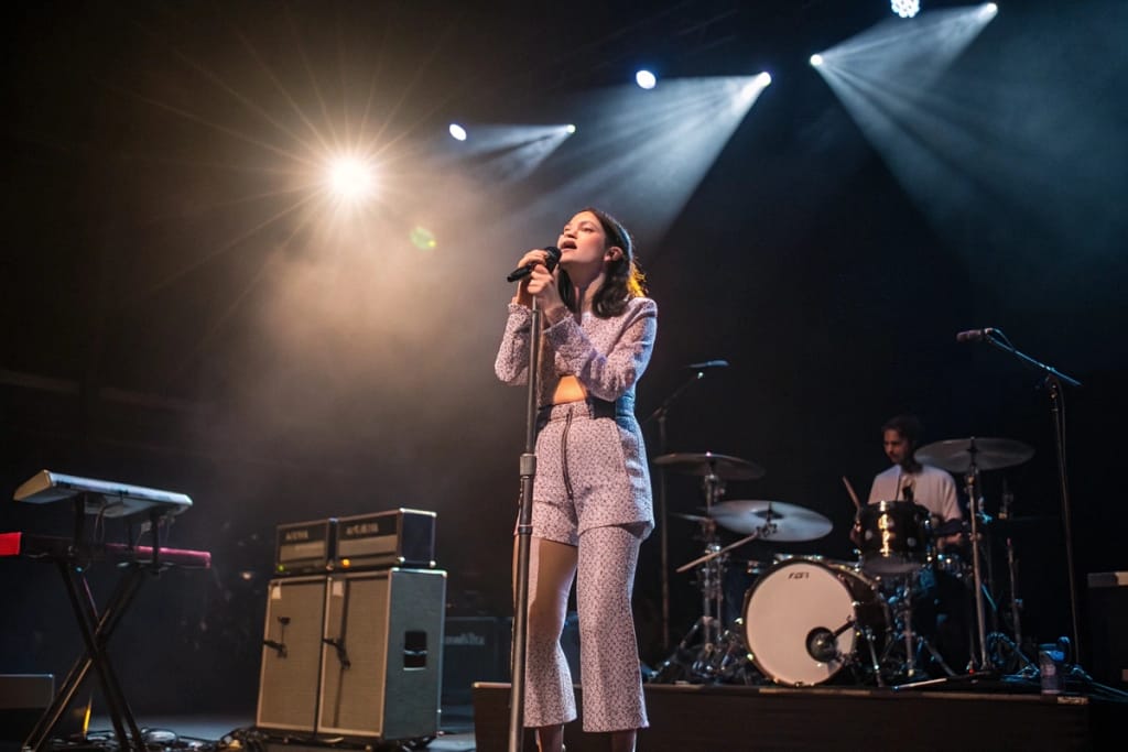 Michelle Zauner of Japanese Breakfast delivers an emotive performance, embodying the band’s fusion of indie rock and cultural flair.