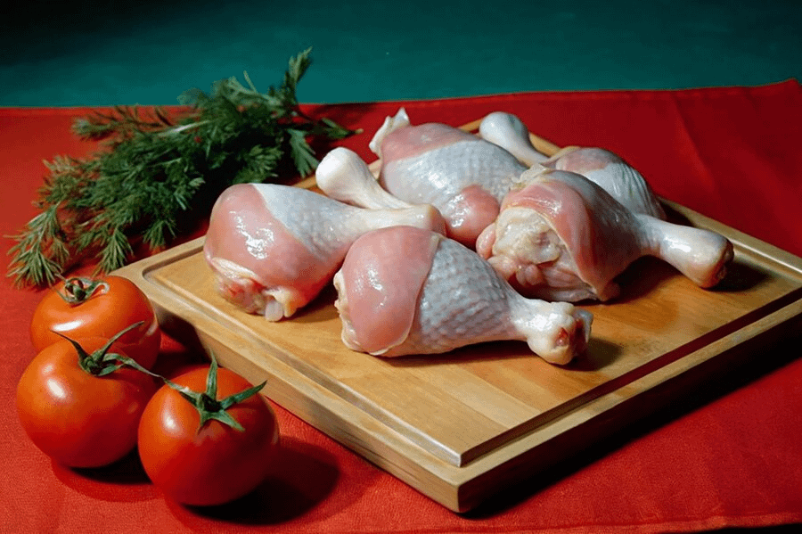 Pieces of chicken (thighs, wings, breasts, drumsticks) arranged on a cutting board, ready to be marinated.